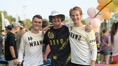 Three college students wearing ultimate frisbee jerseys