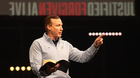 Dr. White holding Bible while preaching in chapel