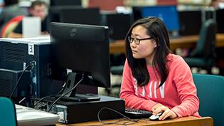 Female student using a computer in Cedarville's library